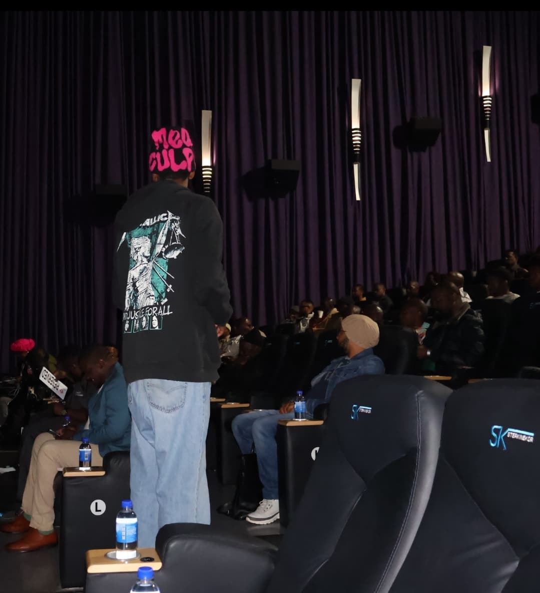 A participant addresses guests seated inside the cinema.