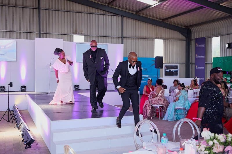 Guests watch a presentation and runway at a foundation event.